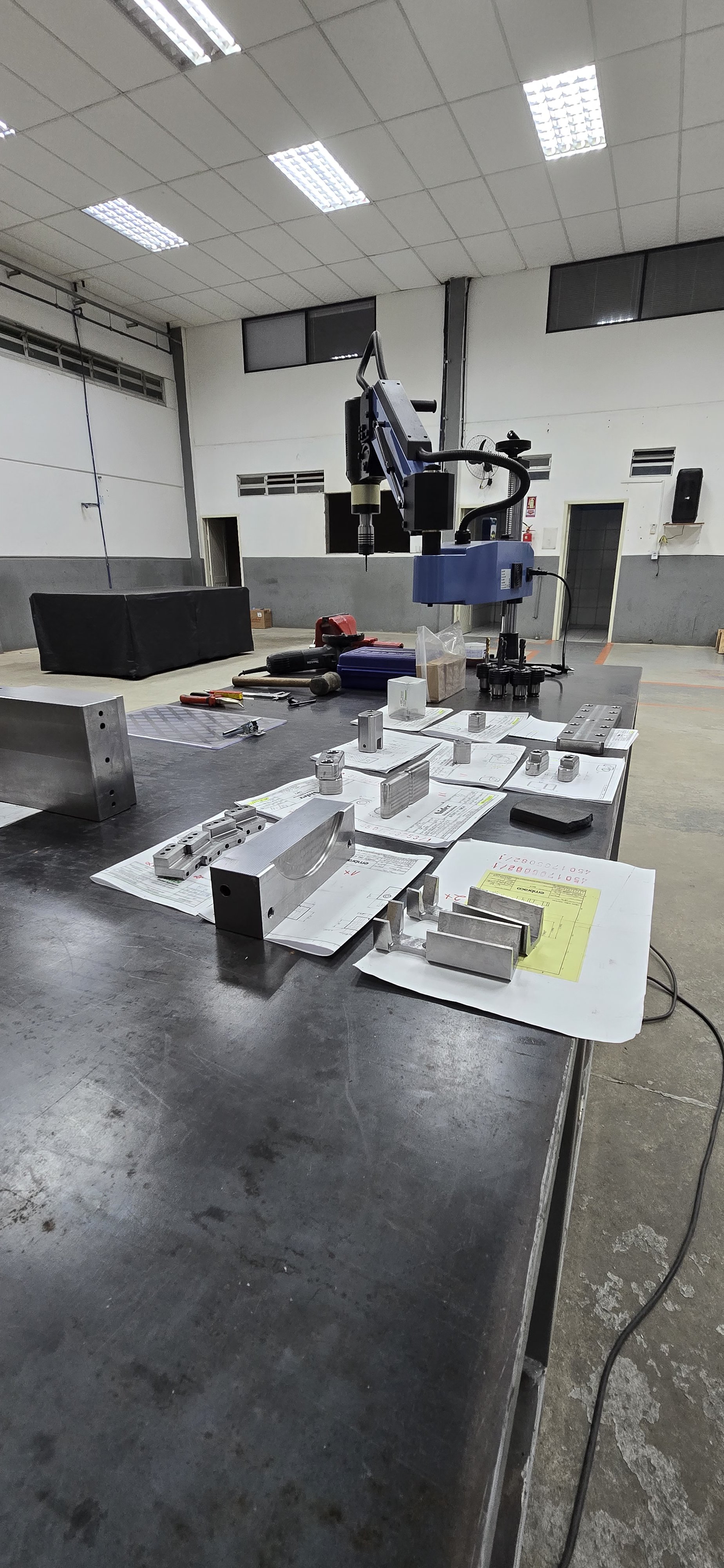 Fábrica da TMS Ferramentaria com maquinário CNC e peças usinadas sobre bancada